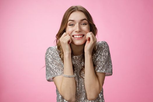 Ehtusiastic attractive young birthday girl celebrating throw party invite friends smiling happily having fun fantastic day pulling cheeks sincere grin standing delighted amused pink background.