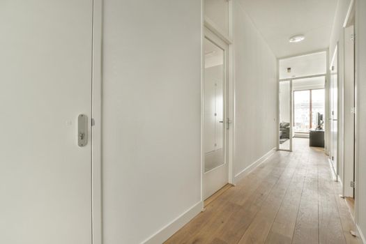 Interior of the narrow corridor with telephone hanging on the wall against stairway in daylight