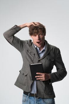 Young brown haired surprised man smiling touching head gesture on camera isolated on white background. Wow expression.