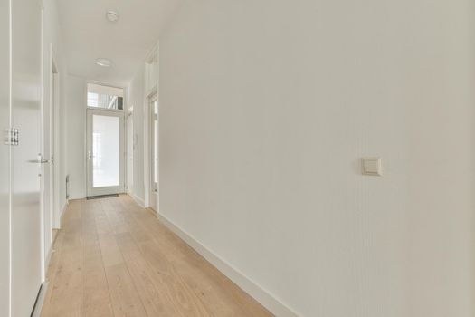 Interior of the narrow corridor with telephone hanging on the wall against stairway in daylight