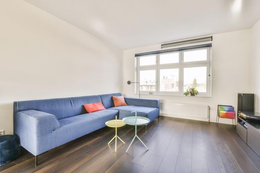 Attractive living room with blue sofa and glass blue and yellow coffee table
