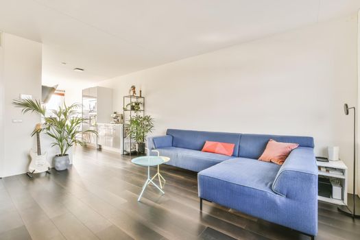Attractive living room with blue sofa and glass blue and yellow coffee table