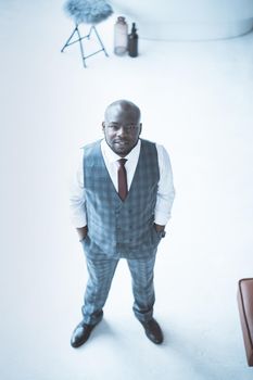 Confident Young Man of 30s in Formal Plaid Suit, White Shirt and Tie, Hands Shoved Into Pockets. White Background. Top View. Full-length. High quality photo