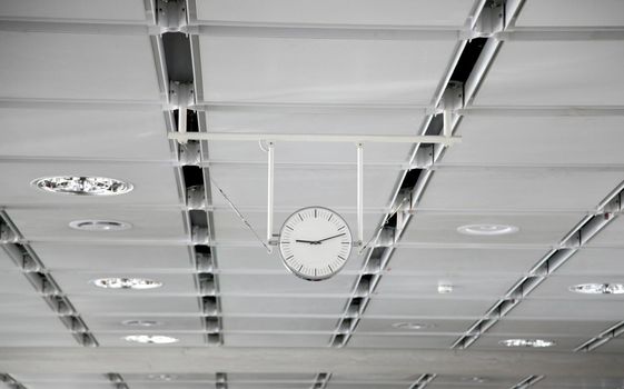 Hanging white clock at the big train station - Photo