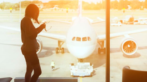 A young girl at the airport is boarding a plane at sunset, a woman goes on a journey.