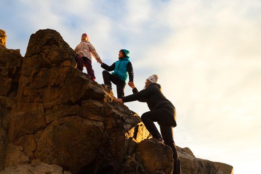 Small children help mom to climb the mountain. High quality photo