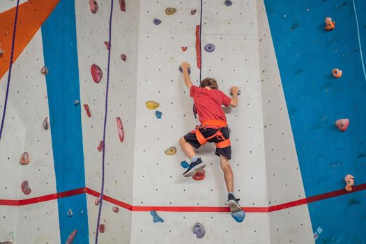 Boy at the climbing wall without a helmet, danger at the climbing wall.