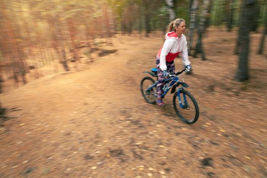 The girl rides a bicycle at high speed. Dynamic background blur. High quality photo