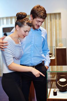 happy young romantic couple in love buy jewelry ring in luxury store