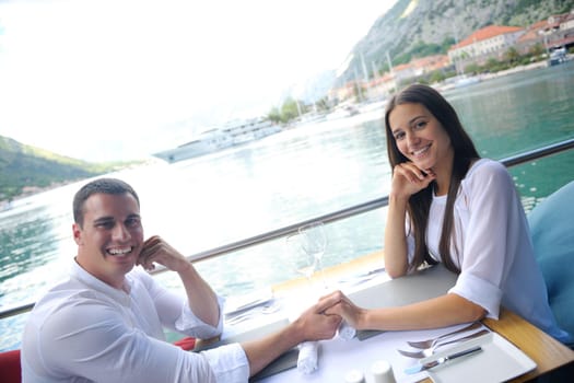 happy young couple having lanch at beautiful restaurant on the beach