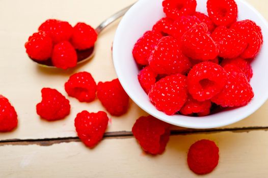 bunch of fresh raspberry on a bowl and white wood rustic  table