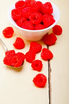 bunch of fresh raspberry on a bowl and white wood rustic  table