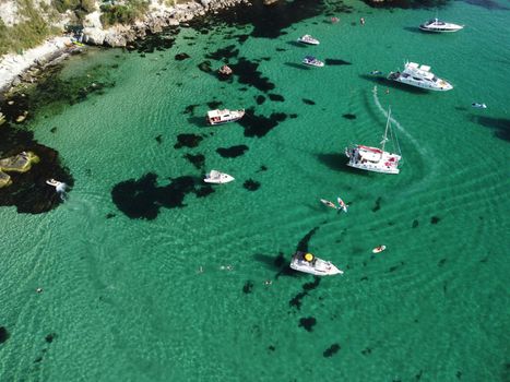Sea landscape with rocky coastline on sunset time with cloudy sky. Yachts in the Sea on a background of rocky shores. The concept of perfect place for summer travel and rest.