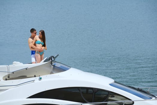 Romantic young couple spending time together and relaxing on yacht