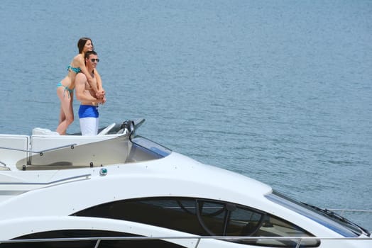 Romantic young couple spending time together and relaxing on yacht