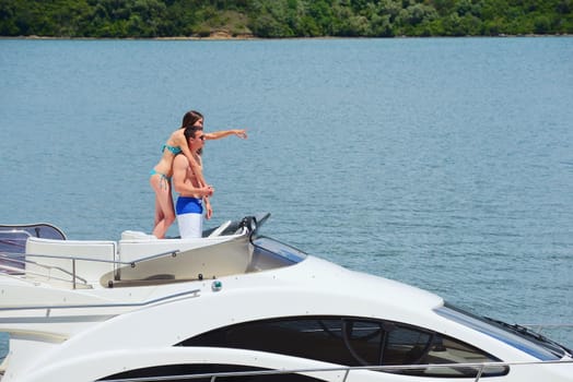 Romantic young couple spending time together and relaxing on yacht