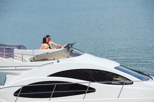 Romantic young couple spending time together and relaxing on yacht