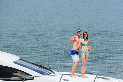 Romantic young couple spending time together and relaxing on yacht