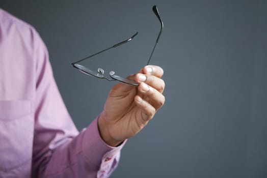 Close up of man hand holding eyeglass,