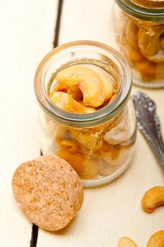 cashew nuts on a glass jar over white rustic wood table 