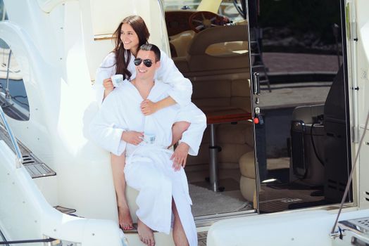 Romantic young couple spending time together and relaxing on yacht