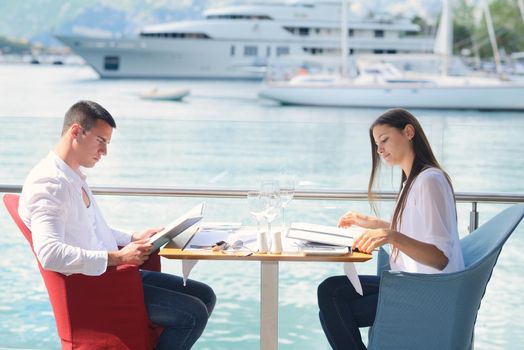 happy young couple having lanch at beautiful restaurant on the beach