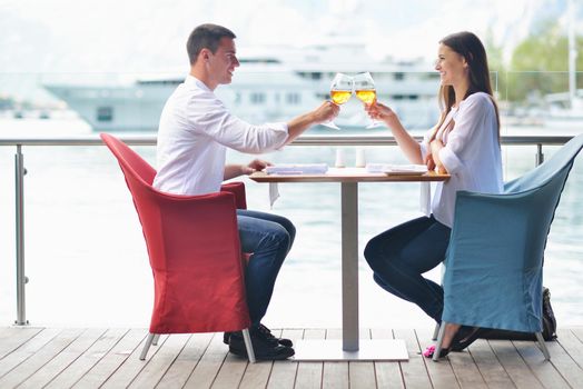 happy young couple having lanch at beautiful restaurant on by the sea on  beach