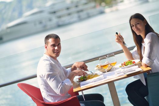 happy young couple having lanch at beautiful restaurant on the beach