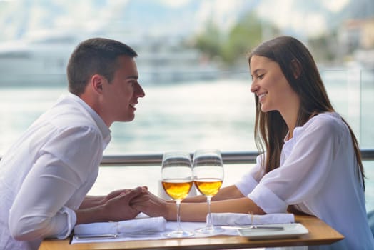 happy young couple having lanch at beautiful restaurant on the beach