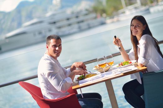 happy young couple having lanch at beautiful restaurant on by the sea on  beach