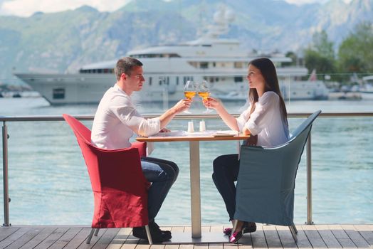 happy young couple having lanch at beautiful restaurant on by the sea on  beach