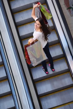 happy young couple with bags in shopping centre mall