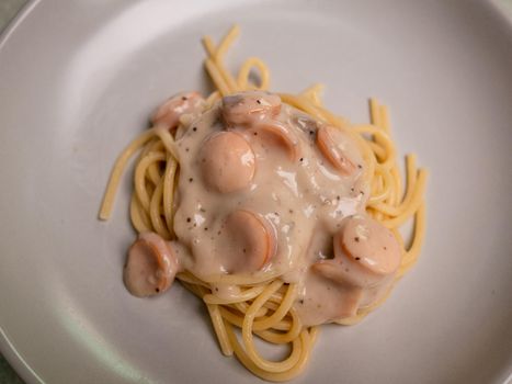 Spaghetti carbonara mushroom sauces with sausages in a plate. Healthy Italian Food and Cooking concepts.