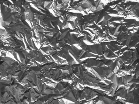 Background texture of crumpled aluminum leaf foil, closeup