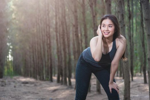 Beautiful sport young woman female lifestyle tired after running workout in forest nature park with copy space