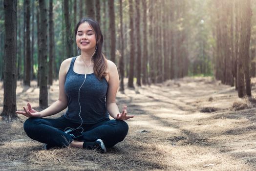 Beautiful young woman relaxation sitting meditation exercise yoga in morning at forest nature park