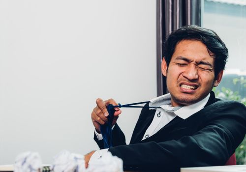 Young asian business man manager frustrated he has tired after work long time