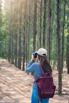 Young female lifestyle photographer travel in forest nature with backpack abd copy space.