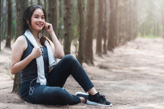 Beautiful sport young woman girl lifestyle exercise healthy drinking water from bottle after running workout in forest nature park with copy space