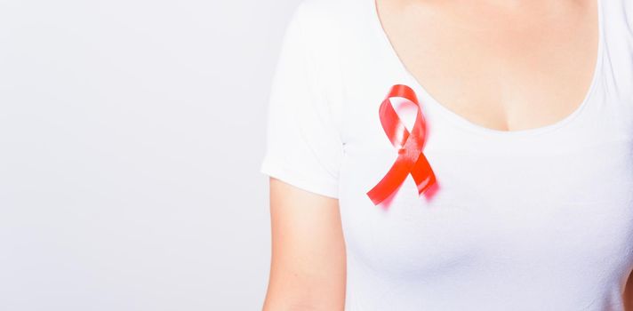 Closeup of female with red ribbon Support HIV AIDS on shirt, World AIDS Day and medicine concept with copy space for use on white background