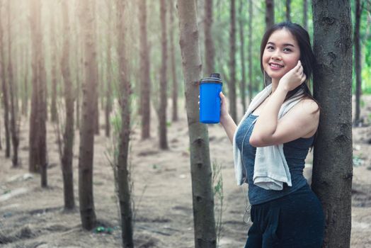 Sport beautiful young woman girl lifestyle exercise healthy drinking protein water after running workout in forest nature park with copy space