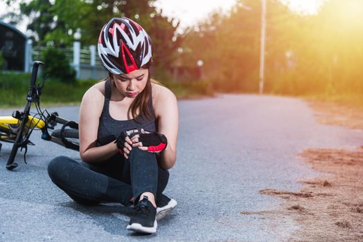 Beautiful young female woman pain injured accident sitting after bicycle falling with copy space