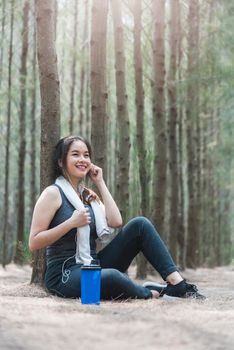 Beautiful sport young woman girl lifestyle exercise healthy break drinking water from bottle after running workout in forest nature park with copy space