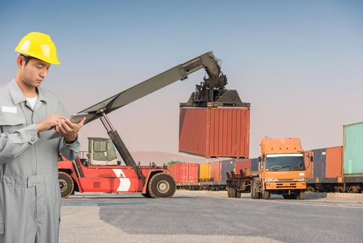 Foreman stand check tablet on front forklift loading Containers box to Logistic cargo Import Export