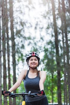 Beautiful young female woman helmet activity bicycle at forest on summer with copy space