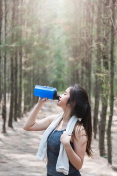 Sport beautiful young woman girl lifestyle exercise healthy drinking protein water after running workout in forest nature park with copy space