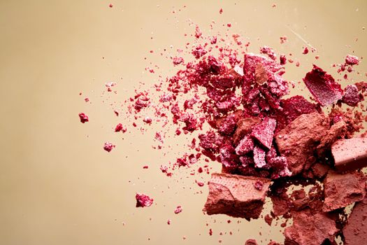 Crushed cosmetics, mineral organic eyeshadow, blush and cosmetic powder isolated on golden background, makeup and beauty banner, flatlay design.