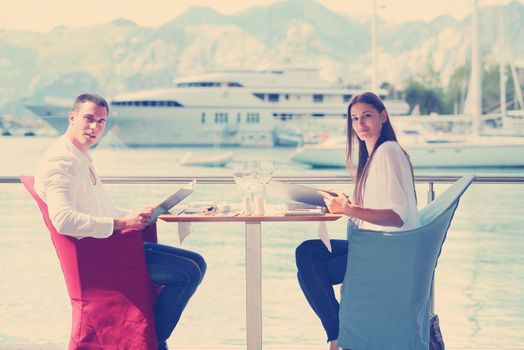 happy young couple having lanch at beautiful restaurant on by the sea on  beach