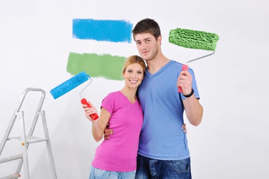 happy young couple paint in green and blue color white wall of their new home