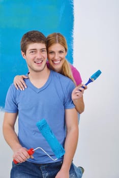 happy young couple paint in green and blue color white wall of their new home